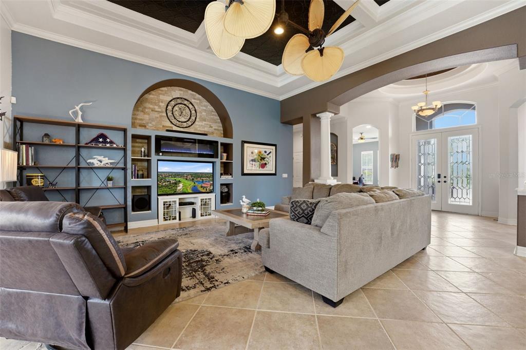 A living room features a stone-accented media wall, a gray sectional, and a ceiling fan — 515 SAND CRANE COURT, BRADENTON, FL
