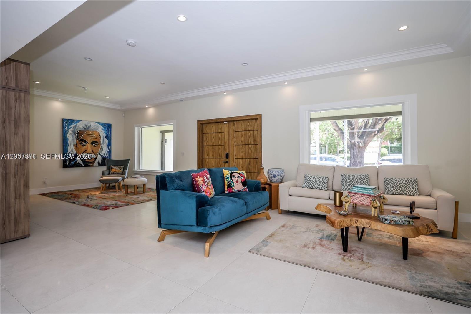 A living room features a blue velvet sofa, a cream sofa, and a live-edge table — 5620 Alton Rd, Miami Beach FL 33140, MIAMI BEACH, FL