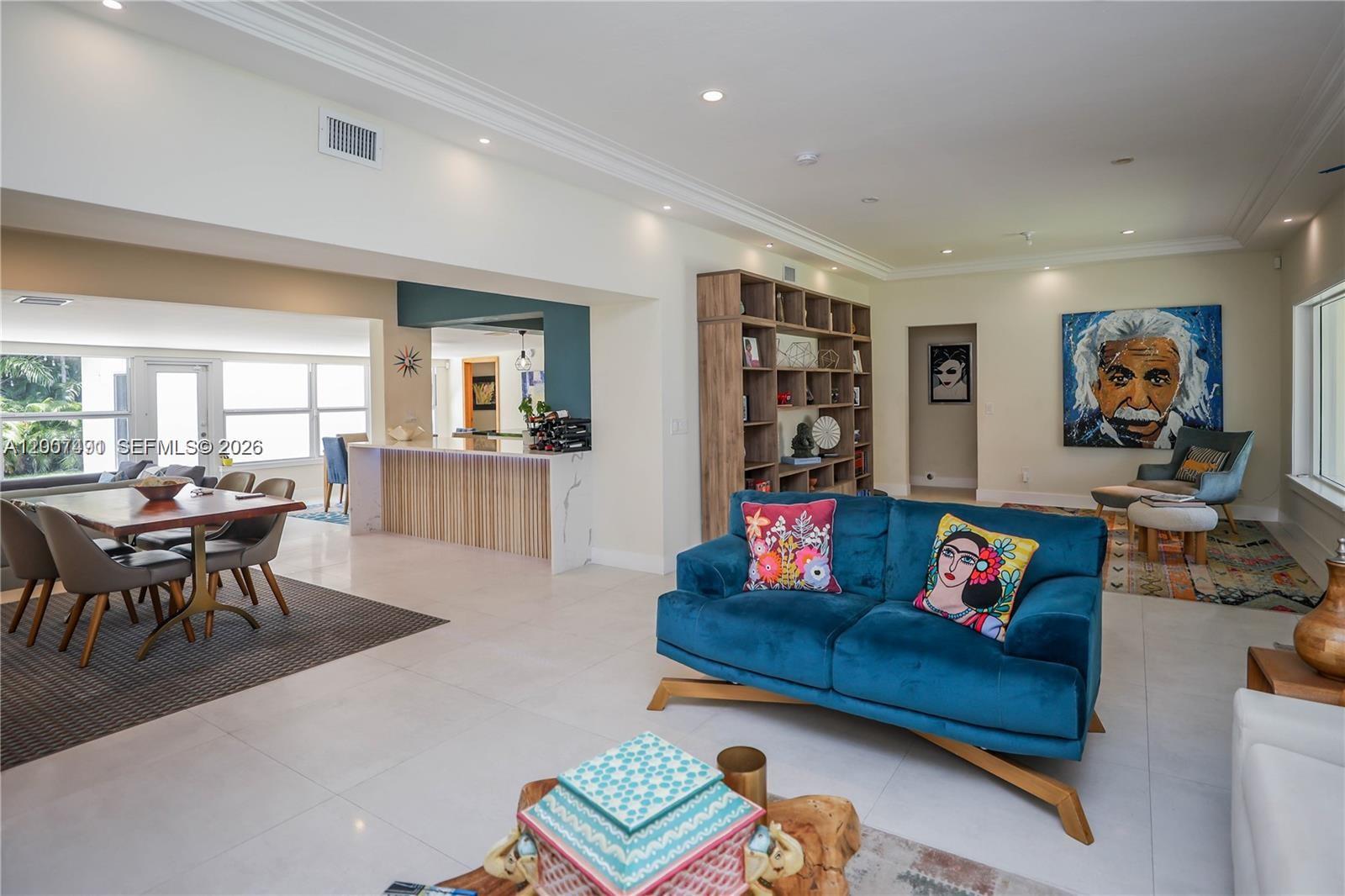 A bright, open-concept living and dining area features white tile floors and modern decor — 5620 Alton Rd, Miami Beach FL 33140, MIAMI BEACH, FL