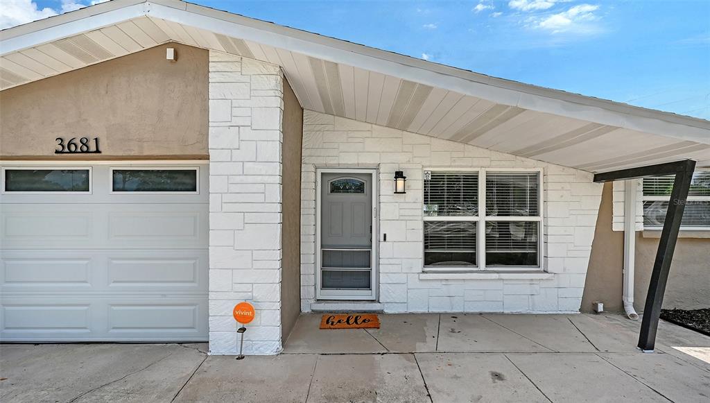 A single-story house exterior features a white stone facade, a garage, and a front porch — 3681 STOKES DR DRIVE, SARASOTA, FL