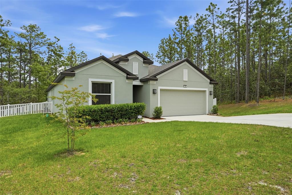A single-story house with a light green exterior, a two-car garage, and a front lawn — 39 MILBARK DRIVE, HOMOSASSA, FL