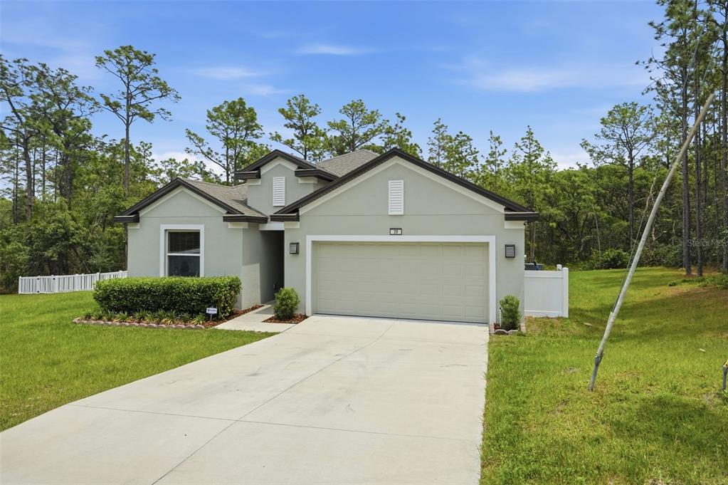 A single-story house with a light green exterior, a two-car garage, and a concrete driveway — 39 MILBARK DRIVE, HOMOSASSA, FL