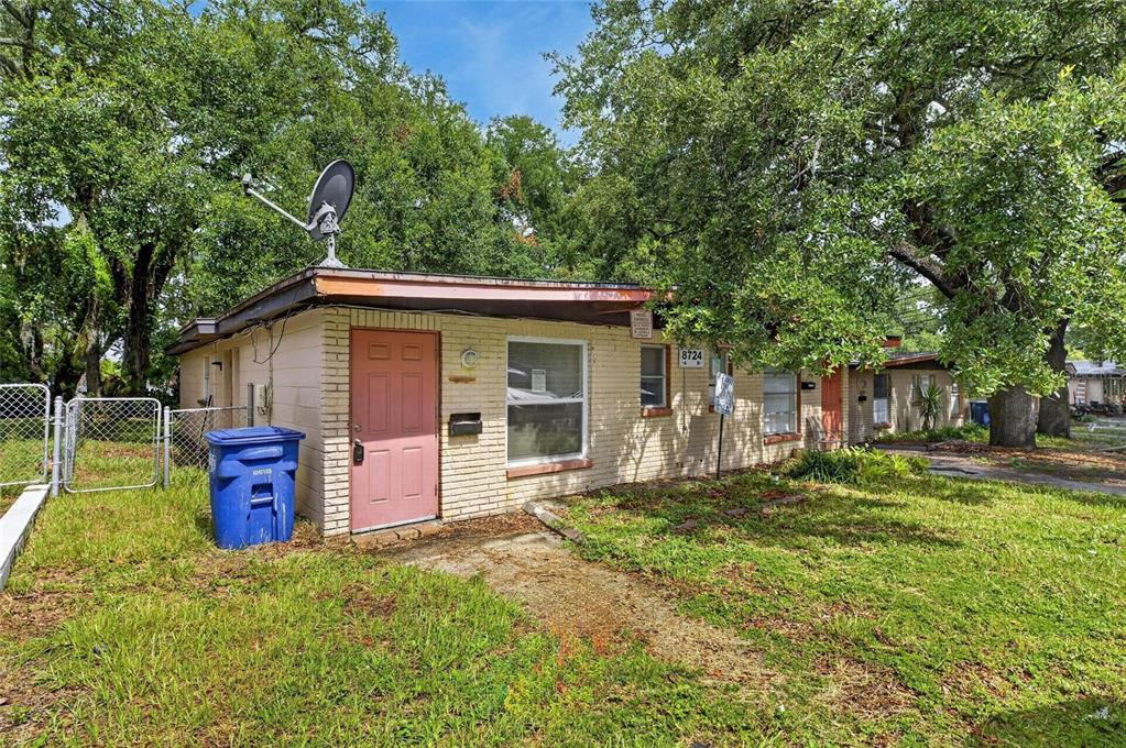 A single-story brick apartment building with a pink door and a satellite dish on roof — 8723 & 8724 N 48TH STREET, TAMPA, FL