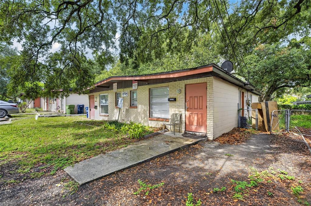 A single-story brick apartment building with a salmon-colored door and a concrete walkway — 8723 & 8724 N 48TH STREET, TAMPA, FL