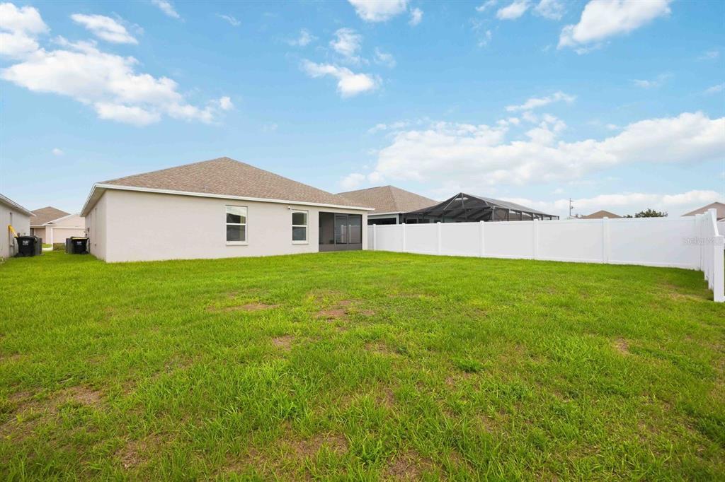A view of the backyard of a house with a white vinyl fence — 8256 CAMPBELL CROSSING CIRCLE, LAKELAND, FL