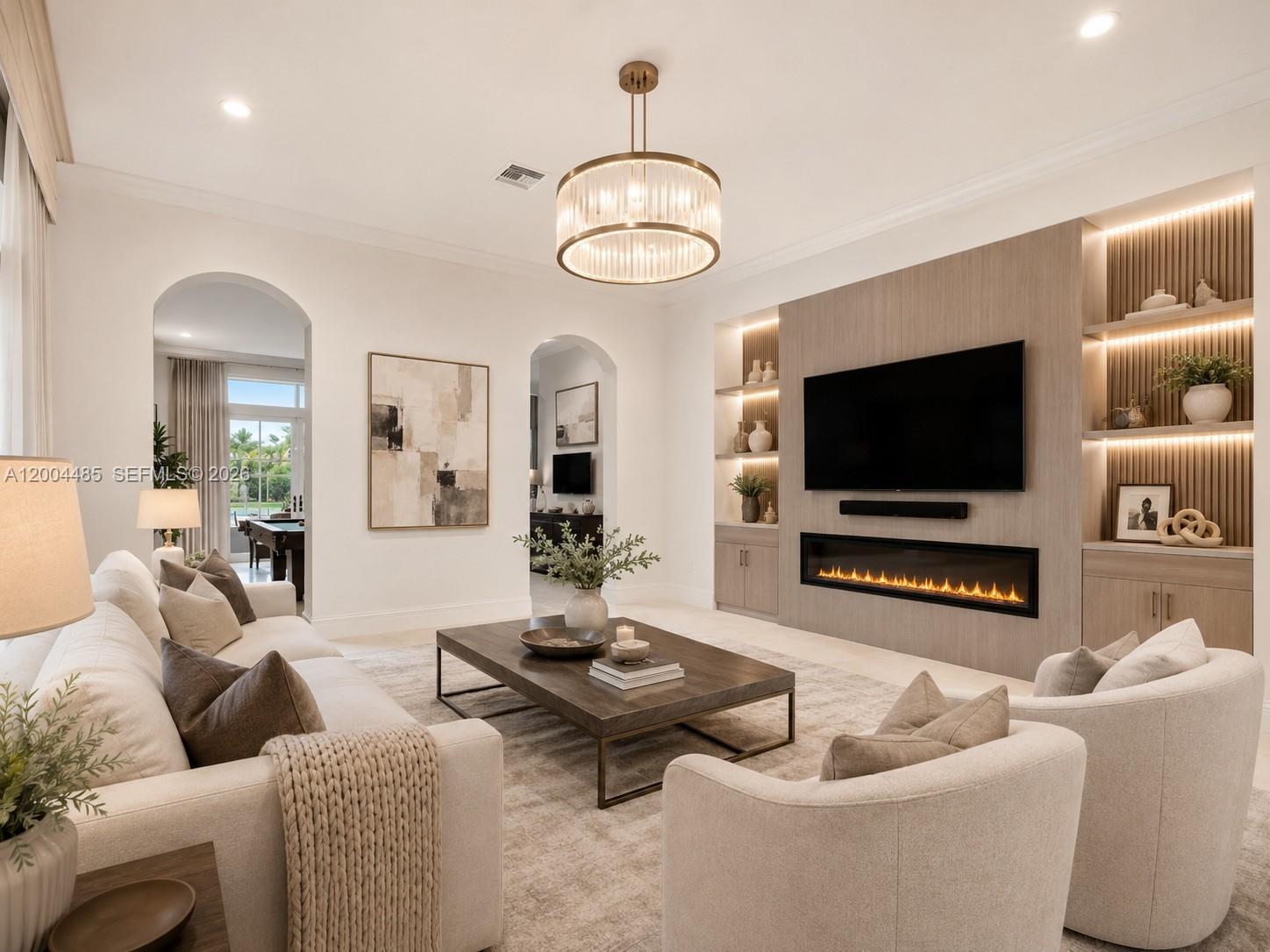 A living room features a fireplace, wall-mounted television, built-in shelving, and neutral furniture — 14857 SW 38th St, Davie FL 33331, DAVIE, FL