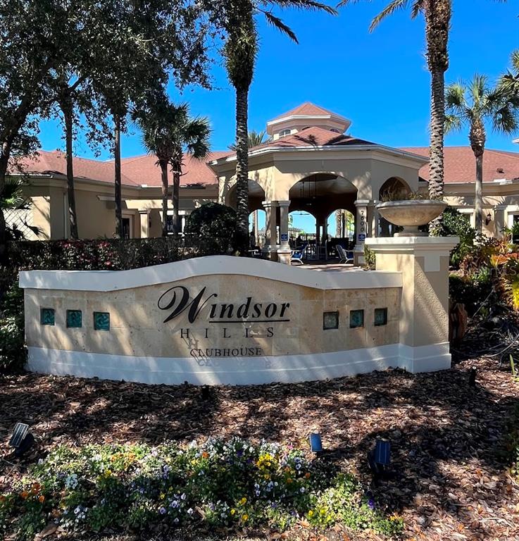 The exterior of the Windsor Hills clubhouse features a stone sign and a covered entryway — 2534 MANESHAW LANE, KISSIMMEE, FL