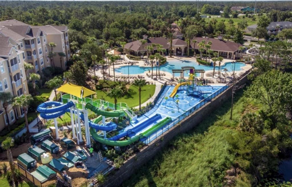 An aerial view of a resort pool area featuring water slides and a splash pad — 2534 MANESHAW LANE, KISSIMMEE, FL