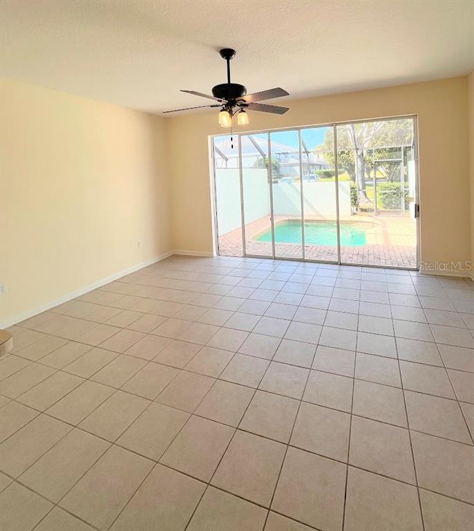 An entryway with tiled floors, a staircase with white railings, and an open front door — 2534 MANESHAW LANE, KISSIMMEE, FL
