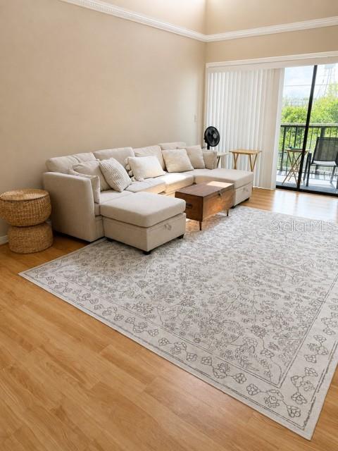 A living room features a beige sectional sofa, a patterned area rug, and a balcony view — 3976 ATRIUM DRIVE UNIT U4, ORLANDO, FL
