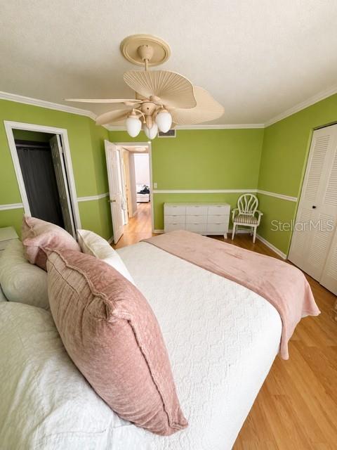 A bedroom features a white bed with pink pillows, a ceiling fan, and green walls — 3976 ATRIUM DRIVE UNIT U4, ORLANDO, FL