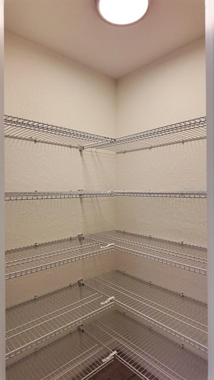 A walk-in pantry features white wire shelving installed along the corner walls — 14973 SW 66 AVE ROAD, OCALA, FL