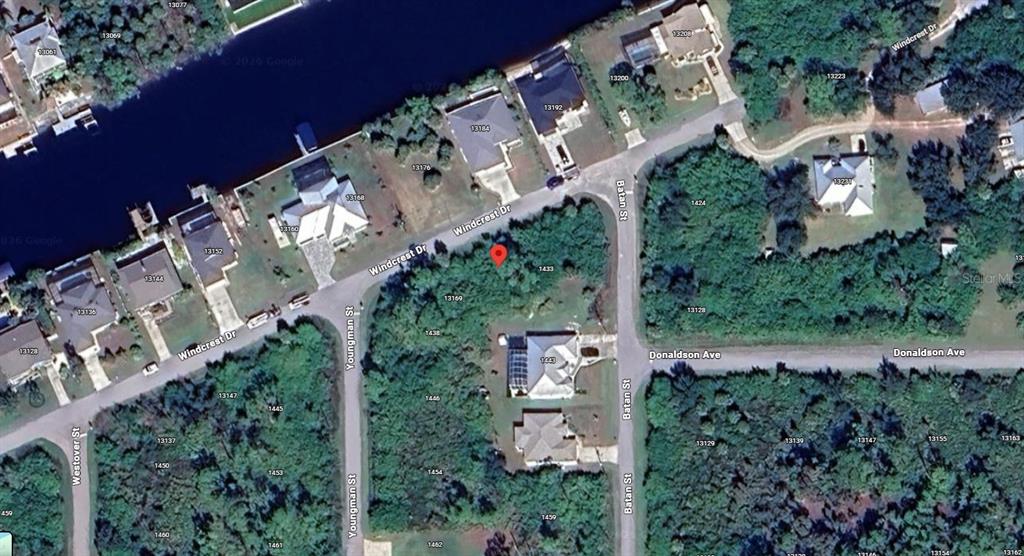 This is an aerial map view of a residential neighborhood with streets and wooded lots — 13177 WINDCREST DRIVE, PORT CHARLOTTE, FL