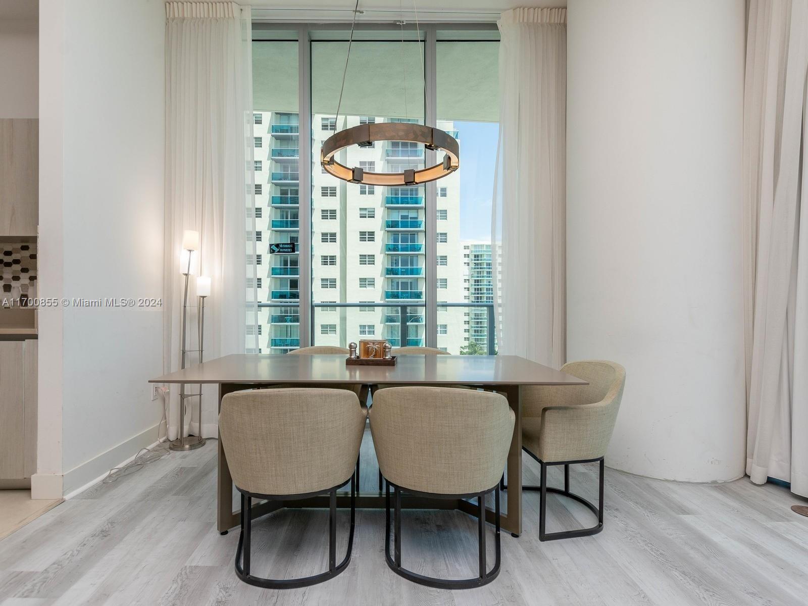 A dining area features a table with four chairs under a circular chandelier near windows — 4111 S Ocean Dr # 601, Hollywood FL 33019, HOLLYWOOD, FL