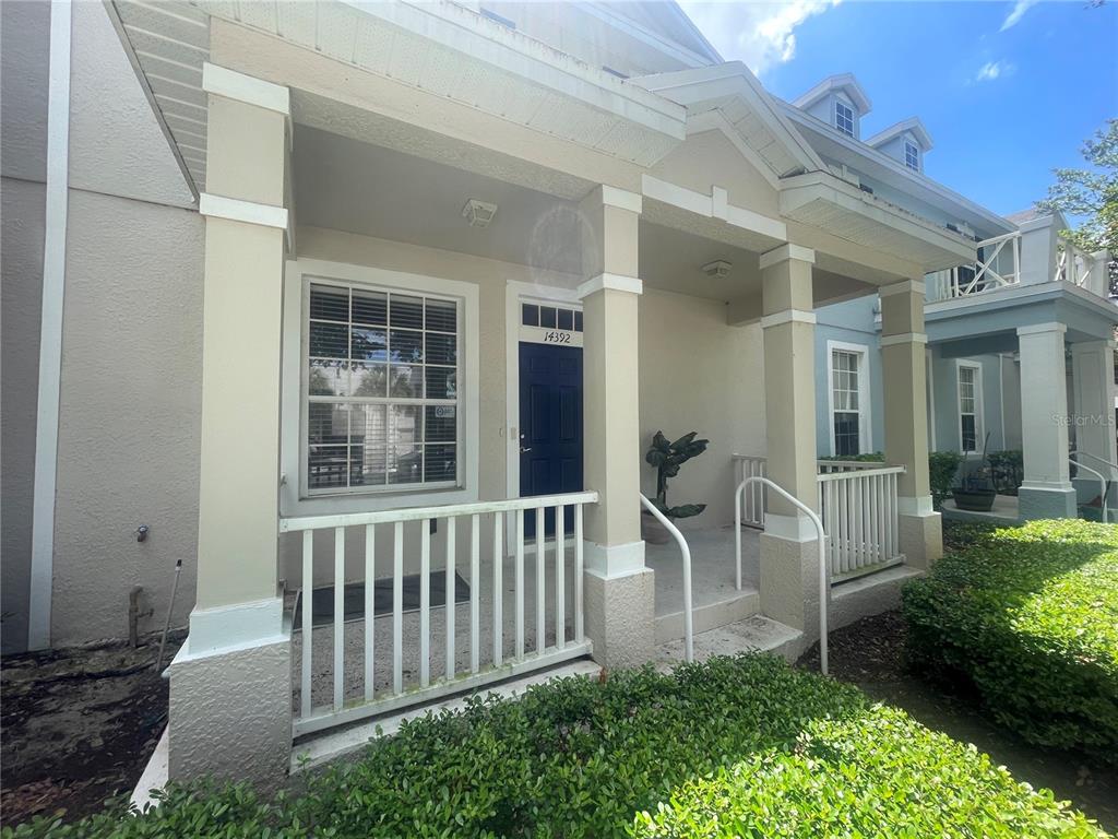 A covered front porch with white railings leads to a dark blue front door — 14392 BRIDGEWATER CROSSINGS BOULEVARD, WINDERMERE, FL