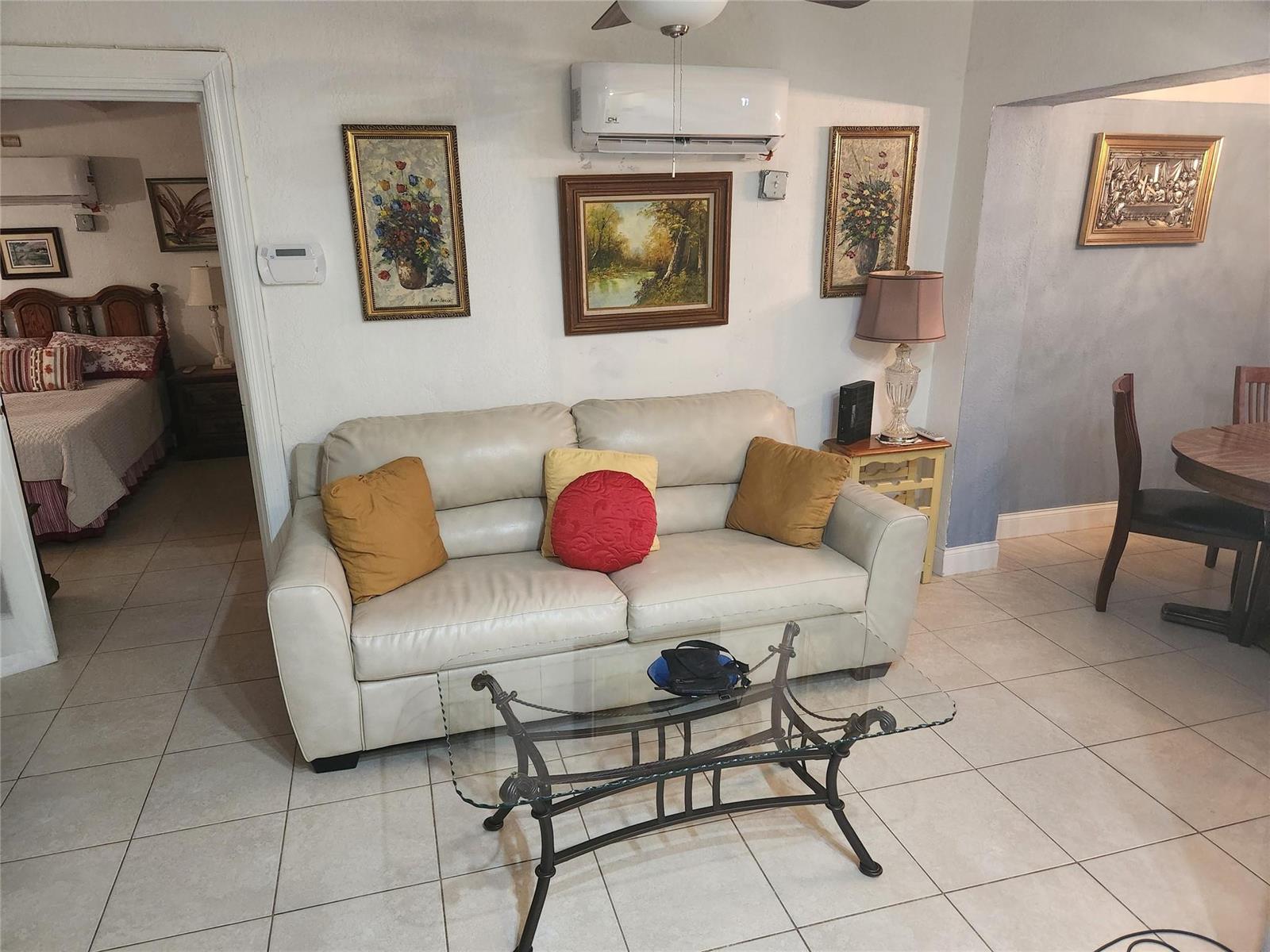 A single-story house with a beige exterior, metal awnings, and a paved front patio area — 1597 NE 53rd Court, Pompano Beach FL 33064, POMPANO BEACH, FL