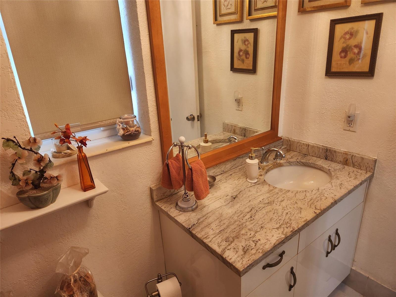 A kitchen features white appliances, granite countertops, and white cabinets against a dark backsplash — 1597 NE 53rd Court, Pompano Beach FL 33064, POMPANO BEACH, FL