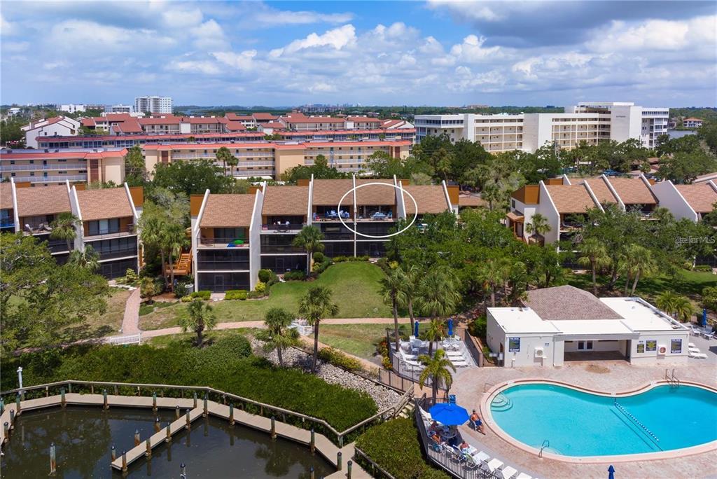 An aerial view of a multi-story condominium complex with a swimming pool and boat docks — 1400 COVE II PLACE UNIT 631, SARASOTA, FL