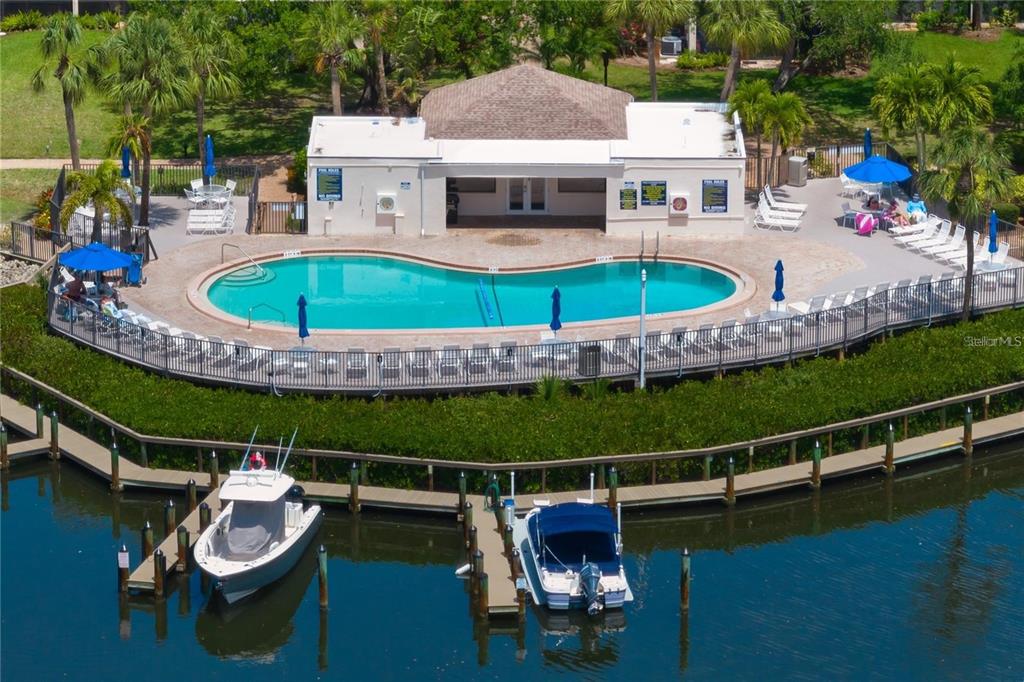 An aerial view of a swimming pool and clubhouse located next to a boat dock — 1400 COVE II PLACE UNIT 631, SARASOTA, FL