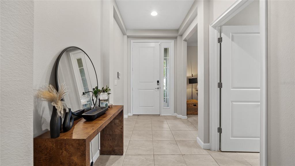 A living room with a gray sectional sofa, a patterned rug, and an open kitchen — 891 JETWAY STREET, ORANGE CITY, FL