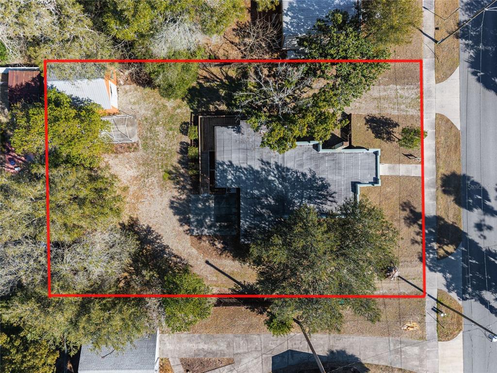 An aerial view shows three houses situated along a street surrounded by many trees — 20707 PARK AVENUE, DUNNELLON, FL