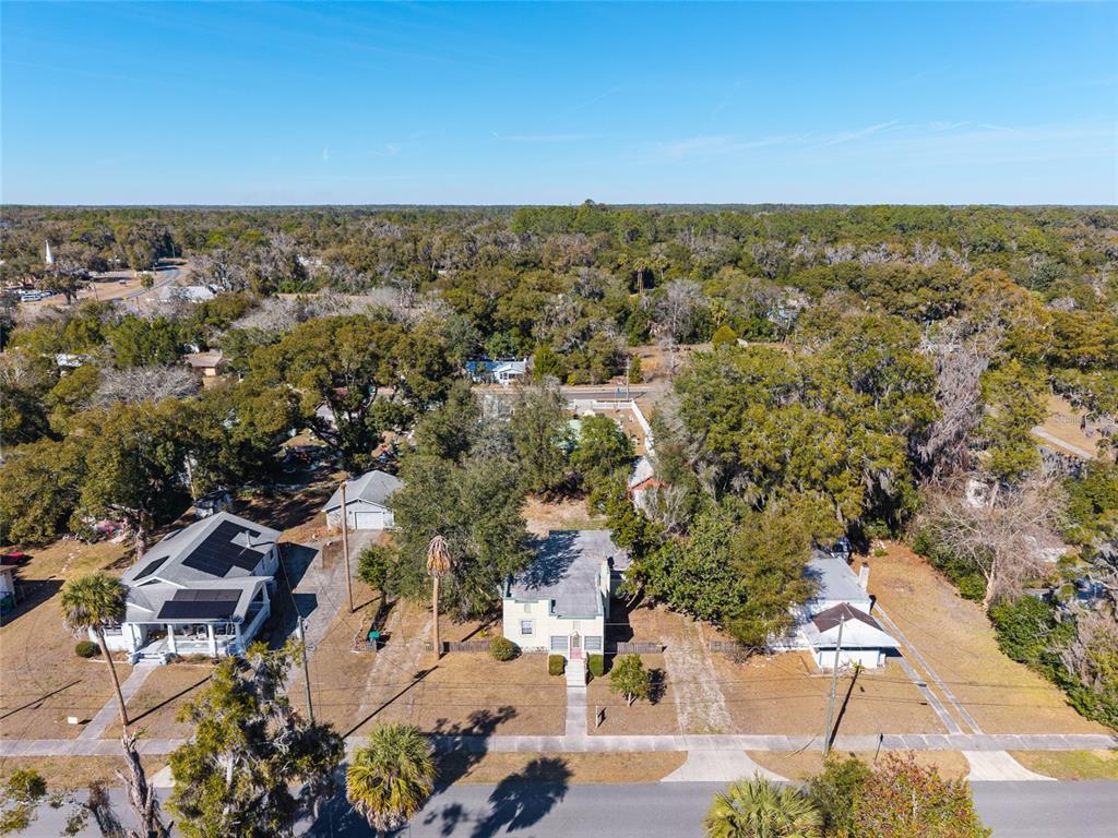 An aerial view shows a residential neighborhood with trees, houses, and a church — 20707 PARK AVENUE, DUNNELLON, FL