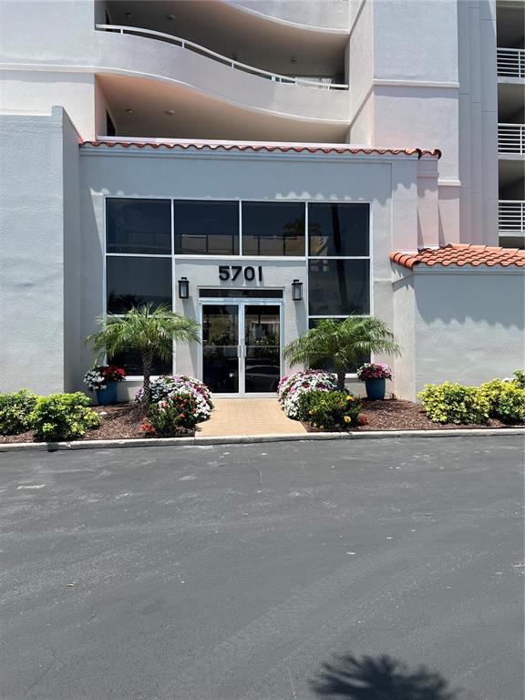 The exterior of a multi-story building features a glass-fronted entrance with the number 5701 — 5701 BAHIA DEL MAR CIRCLE UNIT 508, ST PETERSBURG, FL