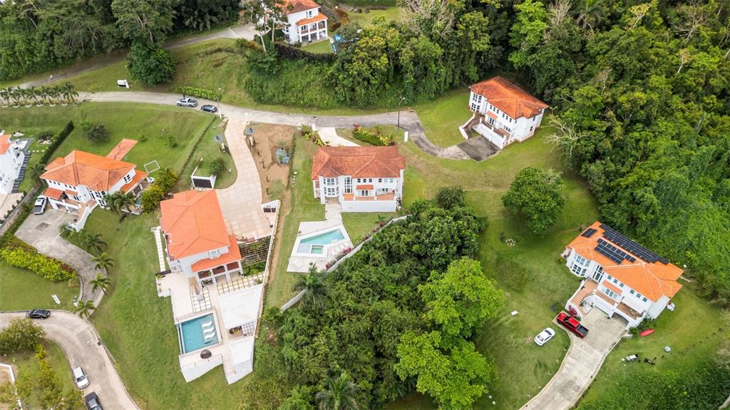 An aerial view shows several houses with orange tile roofs surrounded by lush green trees — Carretera PR-175 KM. 4.0k ESMERALD LAKE PLANTATION, TRUJILLO ALTO, PR