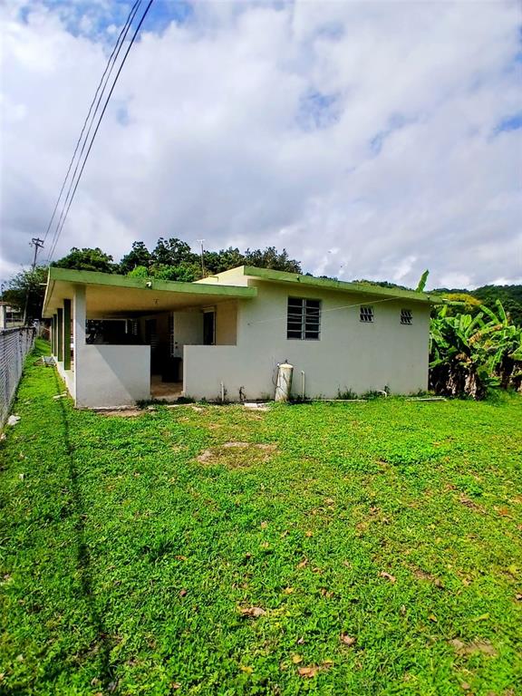 A single-story house with a covered patio and green lawn under a cloudy sky — 372 SECTOR COTUY, YAUCO, PR