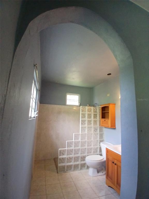 A bathroom features a glass block shower wall, a wooden vanity, and a toilet — 372 SECTOR COTUY, YAUCO, PR