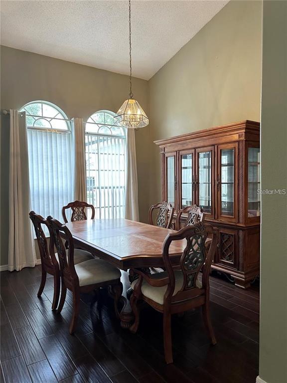 A dining room features a wooden table, six chairs, a large hutch, and arched windows — 16016 BLOSSOM HILL LOOP, CLERMONT, FL