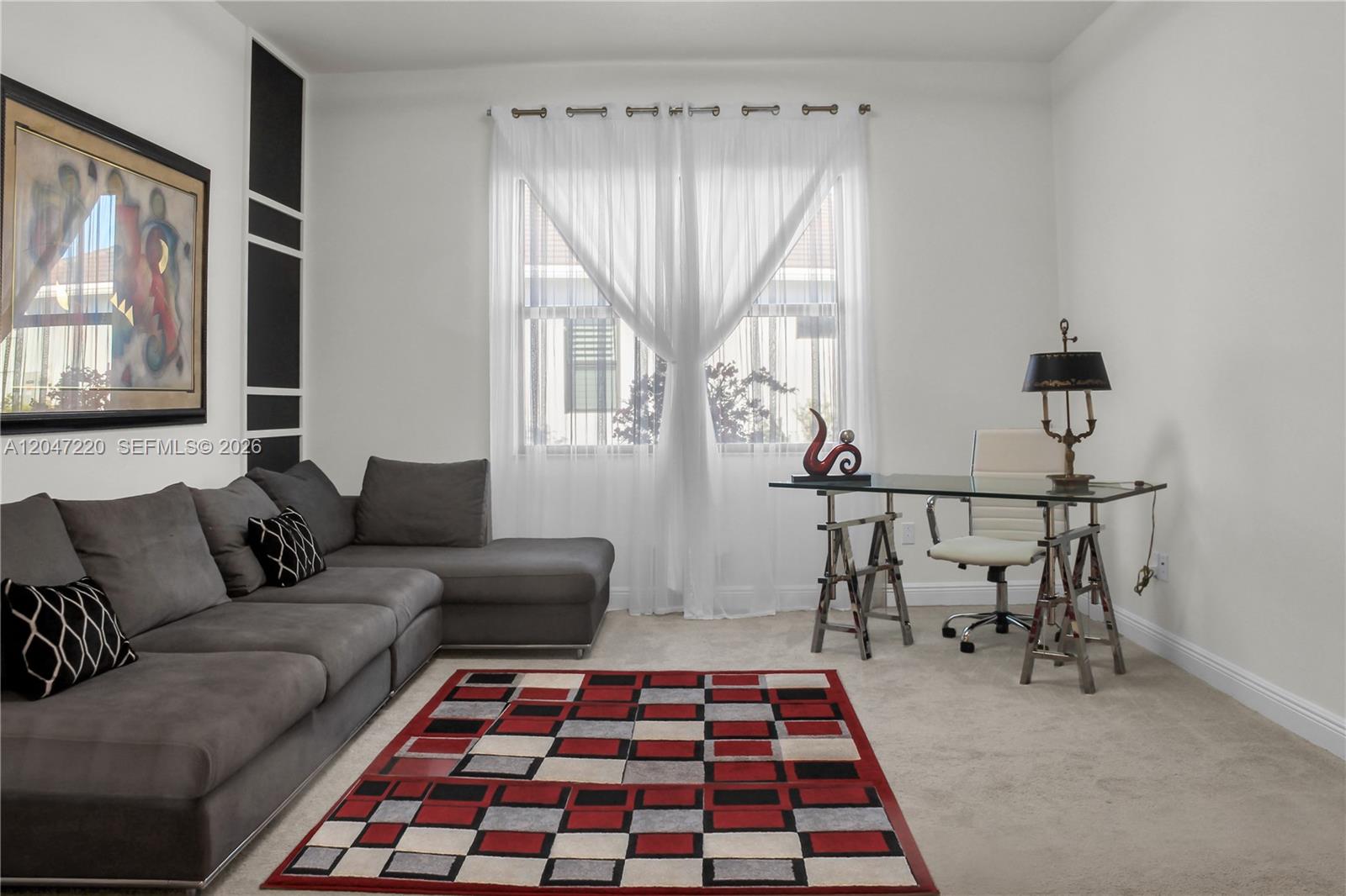 A living room features a gray sectional sofa, a glass desk, and a geometric rug — 15750 Longboat Key Dr, Westlake FL 33470, WESTLAKE, FL