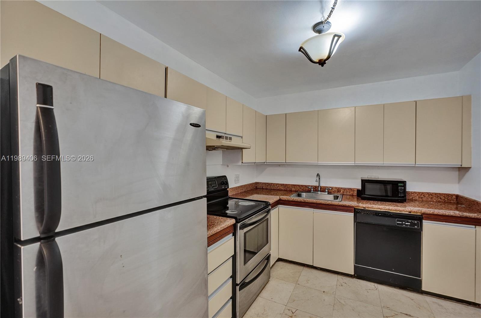 This kitchen features beige cabinets, granite countertops, stainless steel appliances, and a tile floor — 2500 Parkview Dr # 808, Hallandale Beach FL 33009, HALLANDALE BEACH, FL