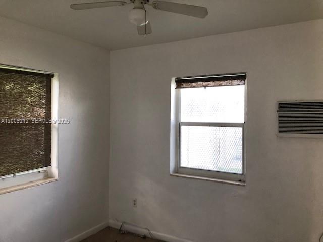 A bedroom with white walls, a ceiling fan, two windows with blinds, and a wall-mounted AC — 471 SW 10th St # 5, Miami FL 33130, MIAMI, FL