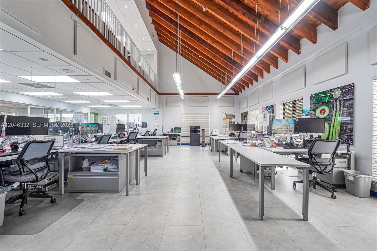 An open-plan office features a high vaulted wood-beam ceiling, white walls, and tiled flooring — 1400 NW 79th Ave, Doral FL 33126, DORAL, FL