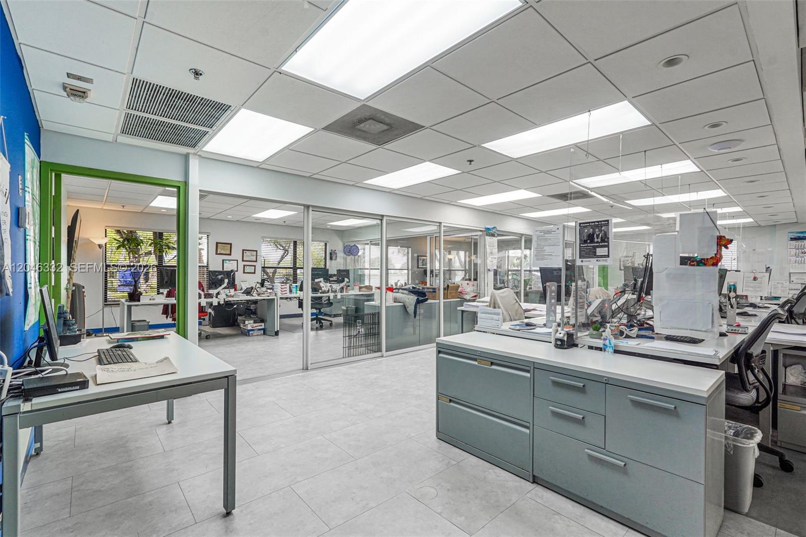 An office space features modular desks, glass partitions, a drop ceiling, and light-colored tile flooring — 1400 NW 79th Ave, Doral FL 33126, DORAL, FL