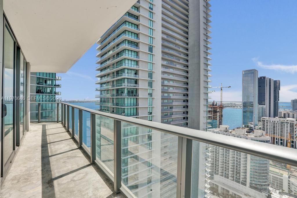 A high-rise balcony with a glass railing overlooks a bay and surrounding city skyscrapers — 501 NE 31st St # 3306, Miami FL 33137, MIAMI, FL