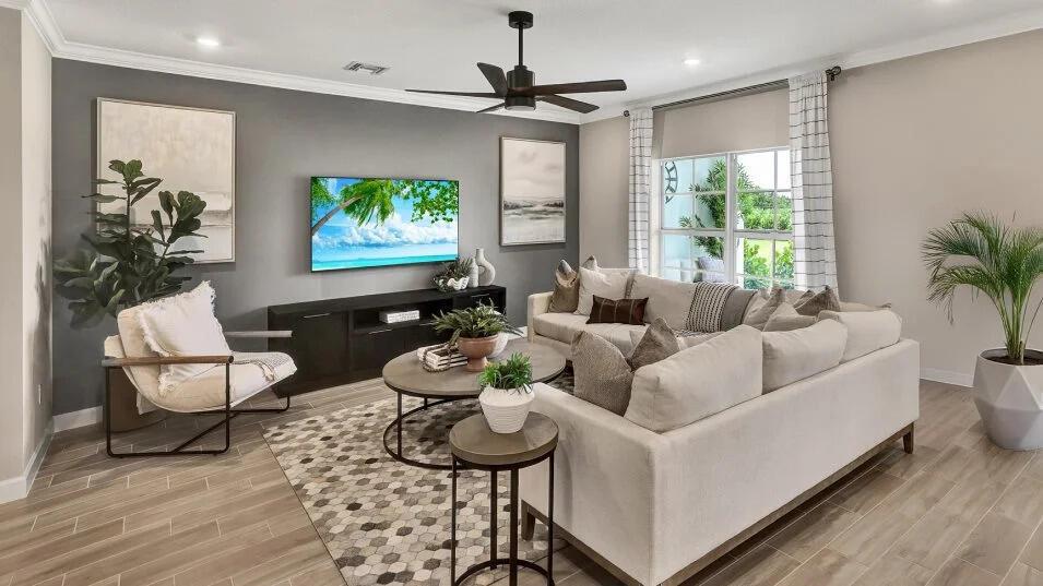 A living room features a grey accent wall, a sectional sofa, and a television — 19868 Whispering Creek Road, FL 33470, FL