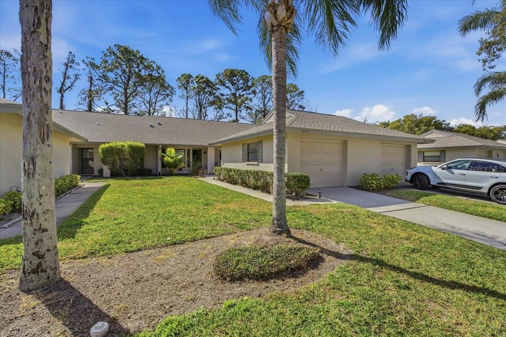 A single-story house with a beige exterior, a two-car garage, and a front lawn — 3272 LORI LANE, NEW PORT RICHEY, FL