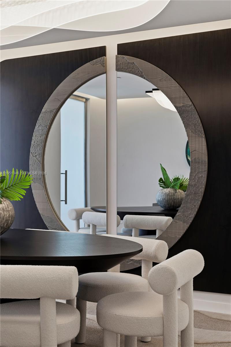 A dining room features a large circular mirror mounted on a dark wood paneled wall — 851 NE 1st Ave # 3411, Miami FL 33132, MIAMI, FL