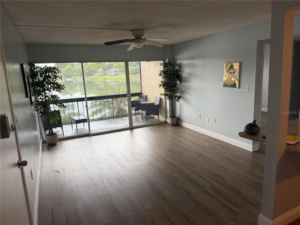 An empty bedroom features light blue walls, wood-look flooring, a ceiling fan, and a window — 620 ORANGE DRIVE UNIT 227, ALTAMONTE SPRINGS, FL