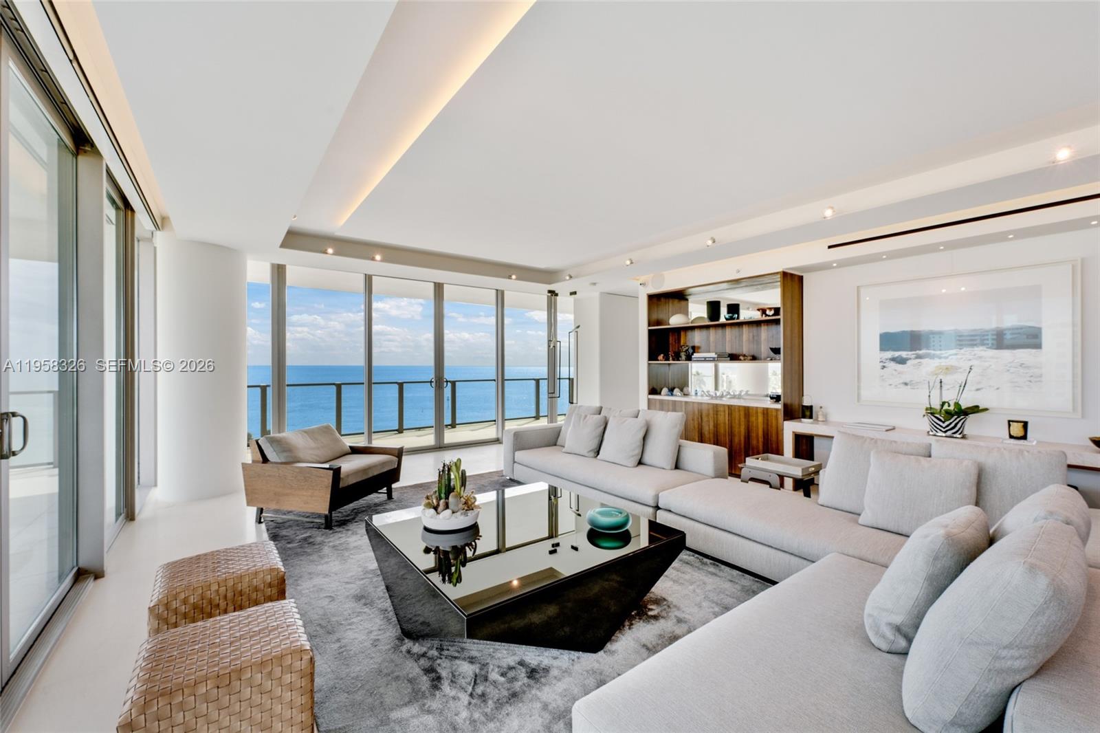 A modern living room features a large sectional sofa, a black coffee table, and ocean views — 350 Ocean Dr # 701N, Key Biscayne FL 33149, KEY BISCAYNE, FL