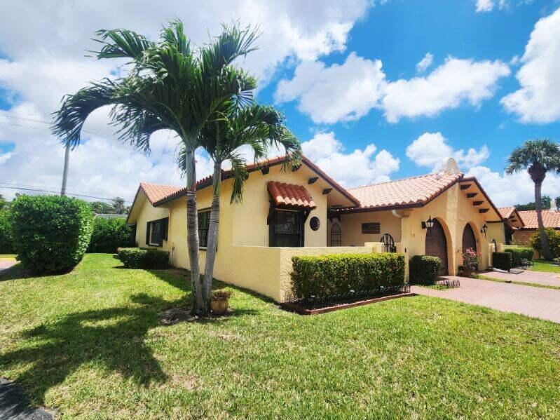 A yellow stucco house with a tiled roof, palm trees, and a landscaped front yard — 5157 Magellan Way E, Delray Beach FL 33484, DELRAY BEACH, FL