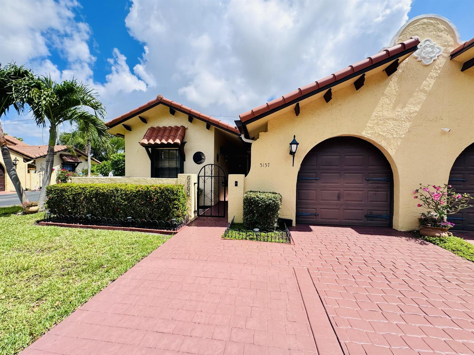A yellow stucco house with a red tile roof, arched garage, and paved driveway — 5157 Magellan Way E, Delray Beach FL 33484, DELRAY BEACH, FL
