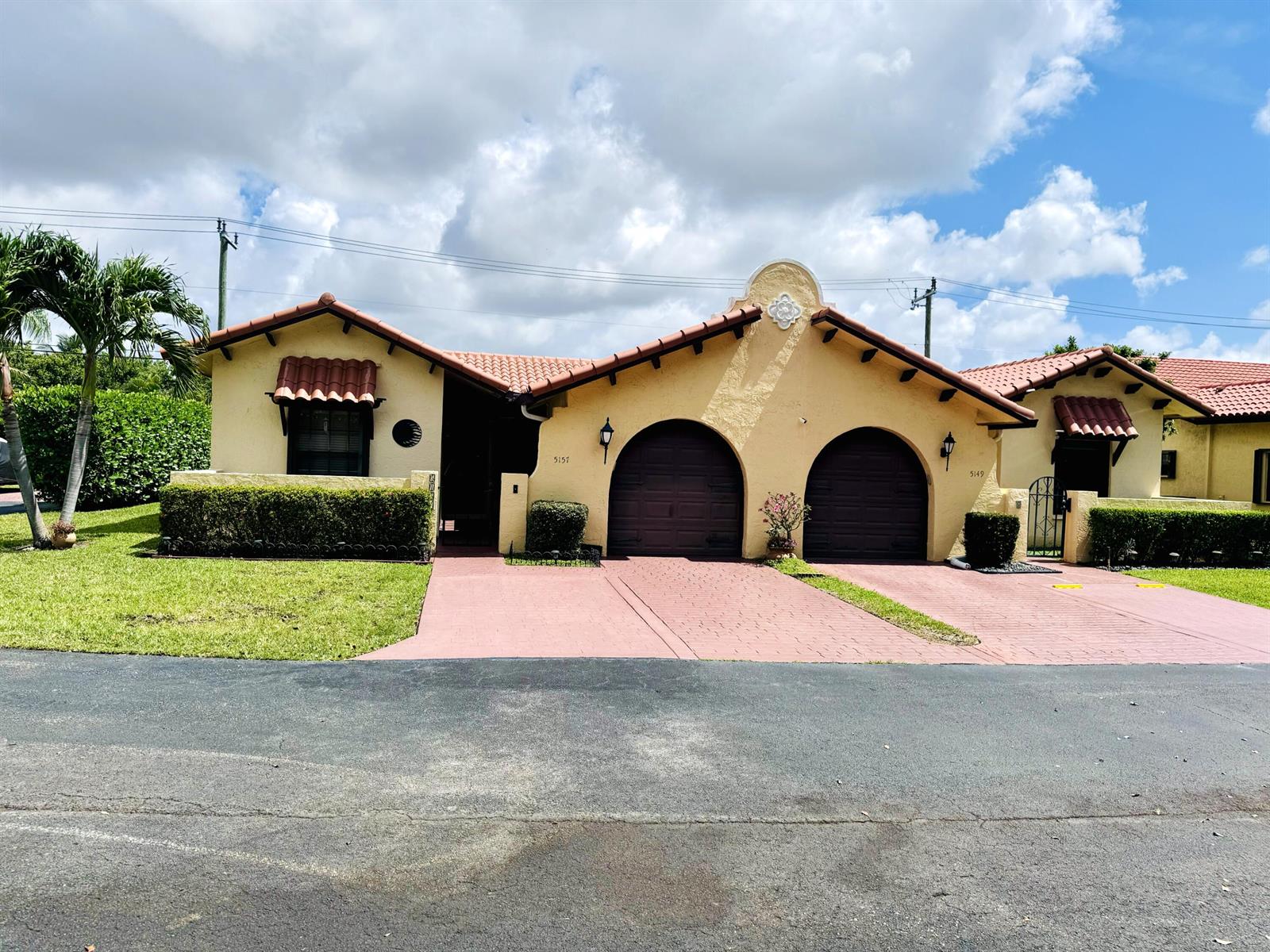 A yellow stucco duplex with arched garage doors and a red tile roof — 5157 Magellan Way E, Delray Beach FL 33484, DELRAY BEACH, FL