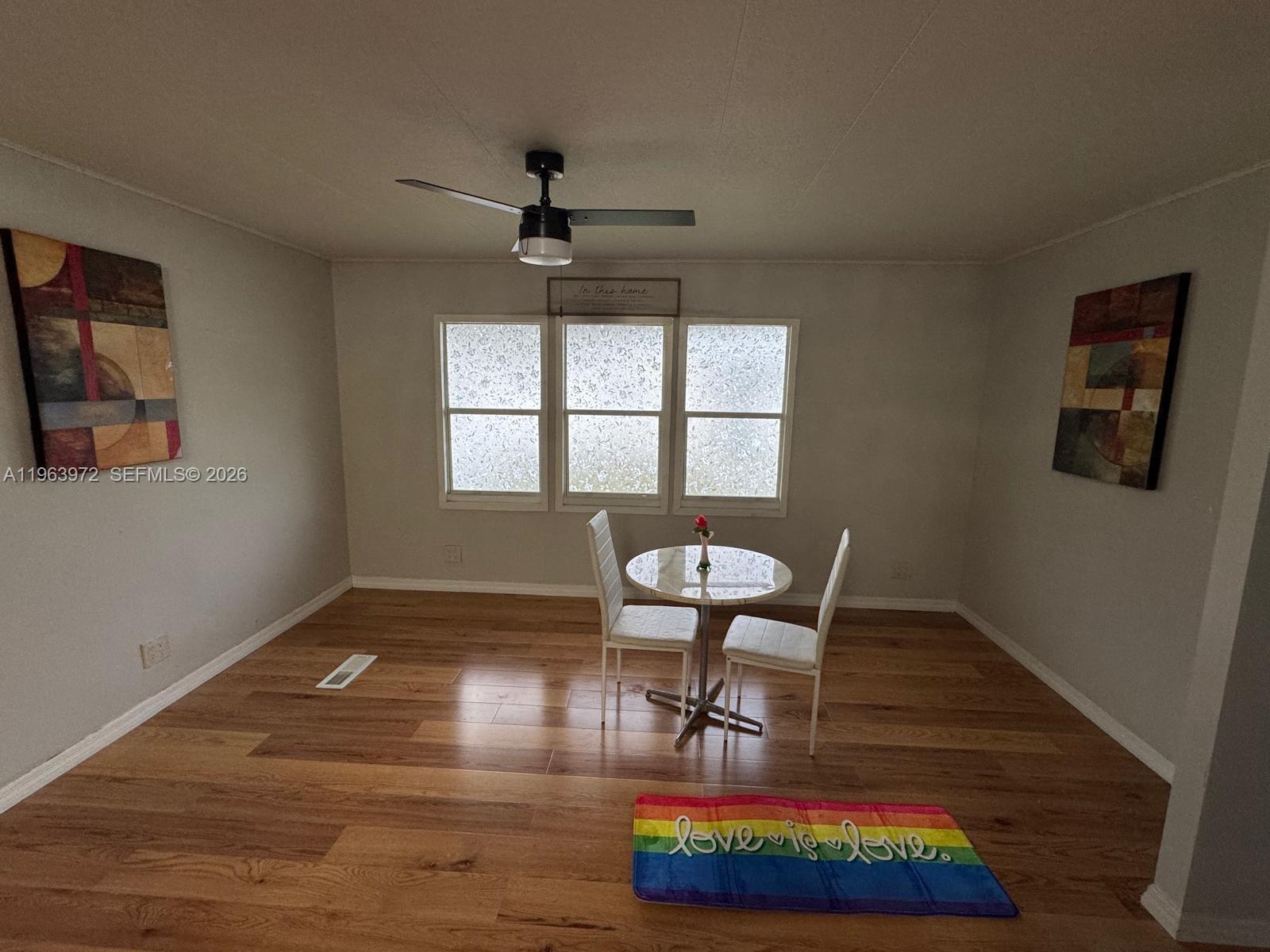 A dining area features wood flooring, a small round table with two chairs, and artwork — 1721 SW 84th Ave, Davie FL 33324, DAVIE, FL