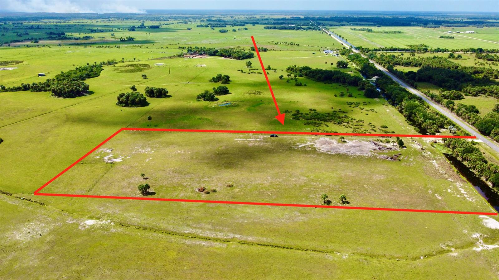 An aerial view shows a large, rectangular plot of vacant land outlined in red — 28095 NW 72nd Avenue, Okeechobee FL 34972, OKEECHOBEE, FL