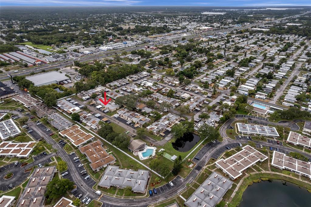 Aerial view of a residential neighborhood with a red arrow pointing to a specific house — 4320 FERN GLEN ST, HOLIDAY, FL