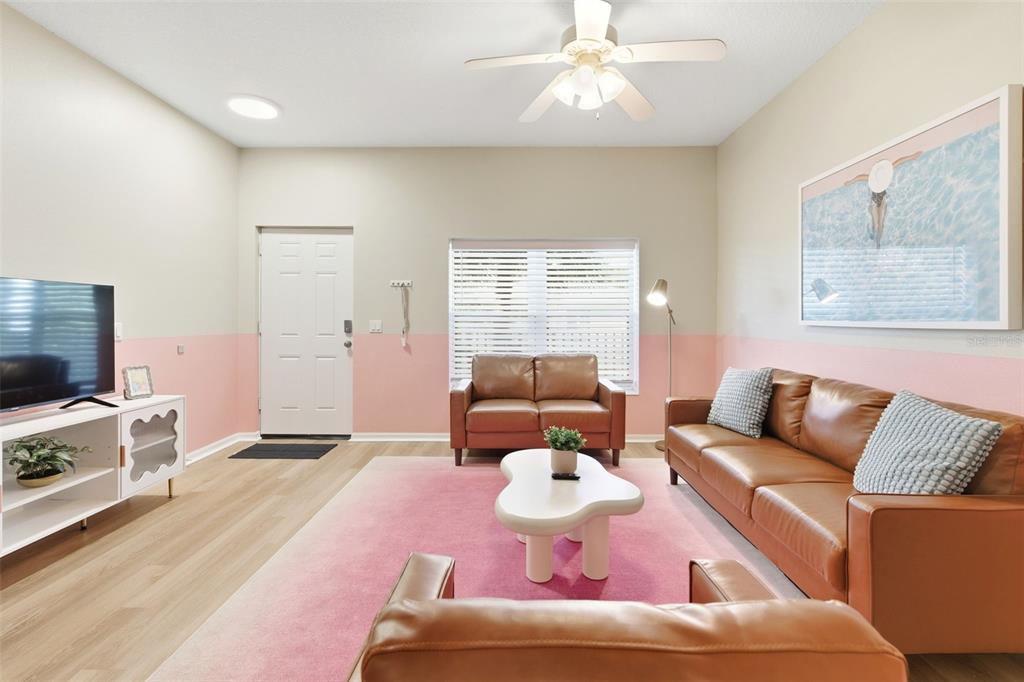 A living room features a pink and beige wall, leather furniture, and a pink area rug — 3119 SUN LAKE COURT UNIT B, KISSIMMEE, FL