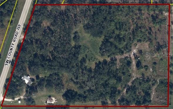 An aerial view shows a large, rectangular plot of land bordering a paved road — 9394 SW COUNTY ROAD 769, ARCADIA, FL